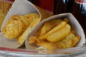 Shrimps, potatoes and vegetables in batter, fried . Street food in cardboard package.