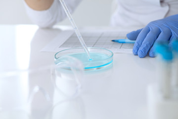 Close up of scientific research hands with clear solution in laboratory