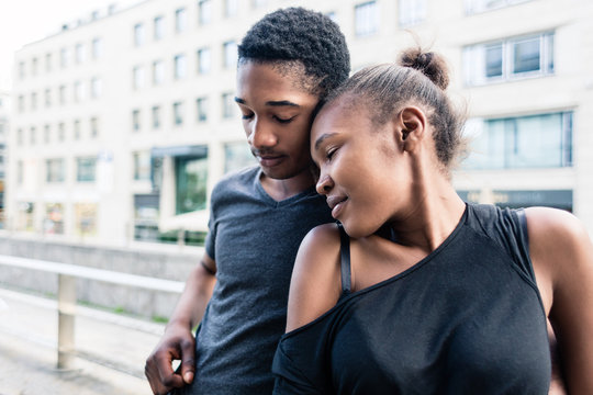 Young African American couple in love standing side by side outdoors in the city