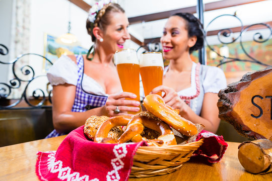 Women in Bavarian pub toasting with wheat beer