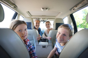 Happy family inside car leaving for vacation