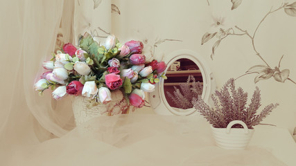  A bouquet of bright roses on the background of different household items and curtains in the dim...