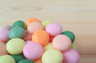 Closed Up Heap of Pastel Color Round Candy on Natural Light Color Wooden Table 