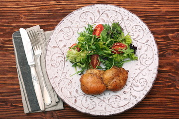 Smoked chicken leg with salad on wooden table