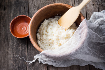 japanese rice in wooden bowl have a wood paddle and white fabric with vinegar in ceramic cup on old wood plank