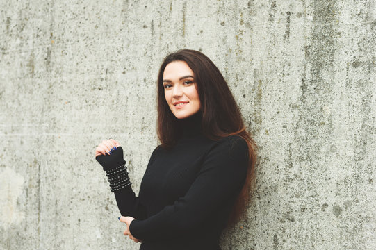 Outdoor Portrait Of Young 35 Year Old Woman With Long Dark Hair, Wearing Black Turtle Neck Dress