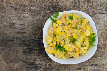 Russian traditional salad olivier on wooden table