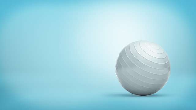 A silver ridged balance ball made of shining rubber placed on blue background.