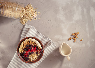 Oatmeal in bowl with berries, bananas and walnuts