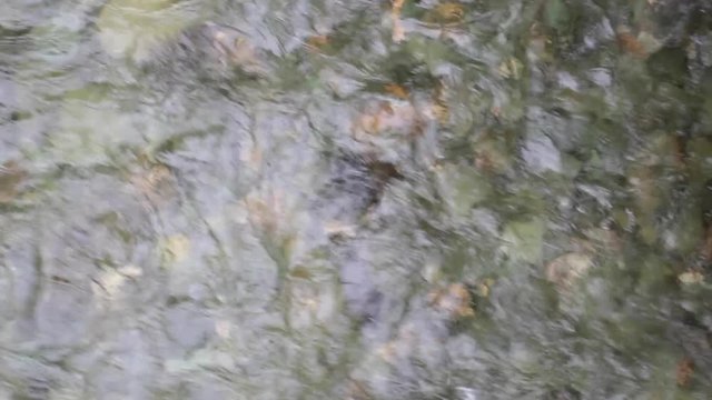 L'eau coule dans une rivi&egrave;re sur des roches de diff&eacute;rente couleur