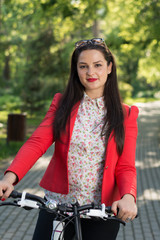 Plakat Portrait of a young woman cycling in the park