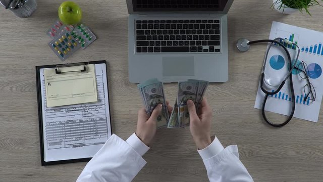 Top view of medical worker counting many dollar bills, expensive healthcare