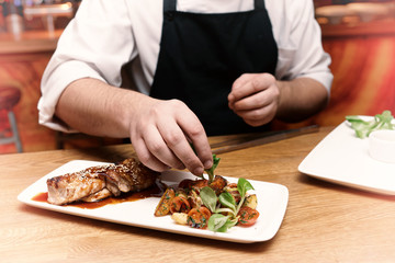 Chef is decorating chicken teriyaki dish, toned