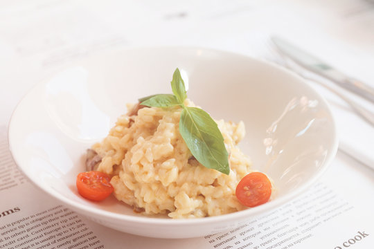 Creamy risotto in porcelain plate, toned