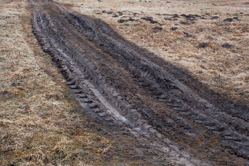 dirty country road with traces from the tractor