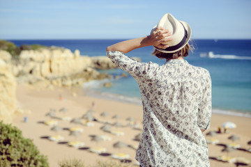 Fototapeta na wymiar Woman on the beach. Back view on sunny outdoors background