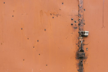 Detail of the painted metal door with old padlocks, closeup