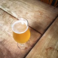 Crédence de cuisine en verre imprimé Bière Glass of unfiltered beer on a bar table