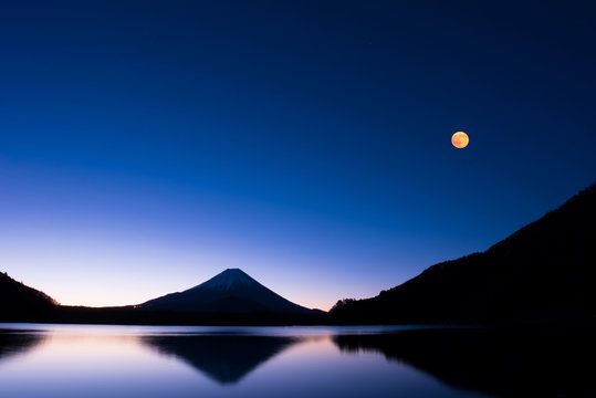 満月と湖に浮かぶ富士山