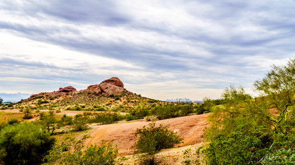 The red sandstone buttes of Papago Park, with its many caves and crevasses caused by erosion under cloudy sky, in the city of Tempe, Arizona in the United States of America