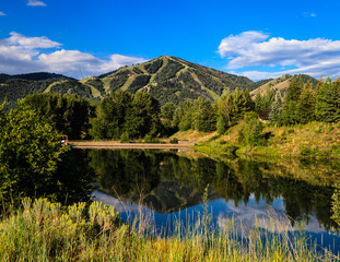 A summer view of Bald Mountain in Sun Valley, with reflection 