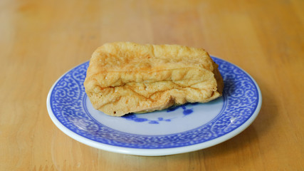Fried bean curd in blue chinese dish on wooden table
