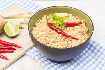 Instant noodles in bowl on wood background