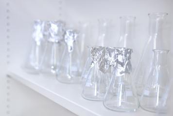 Conical flasks, shelf of clean laboratory glassware