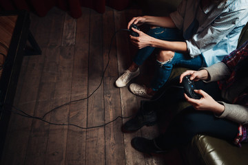 Two unrecognizable girls with joysticks addicted to video game, try to beat high score. Inability...