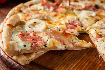 Junk food, bad habits. Pizza sliced on rustic wooden table background. Italian traditional meal