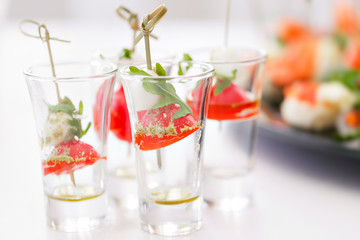 Fresh tasty canapes, closeup. the unusual flow in the shot glass. catering at the event.