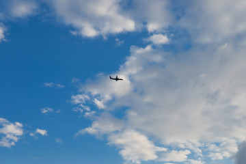 Airplane against blue sky with white clouds