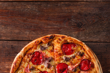 Junk food, bad habits, calories. Fresh pizza with salami, bacon and cheese on rustic wooden table, flat lay with free space for text.