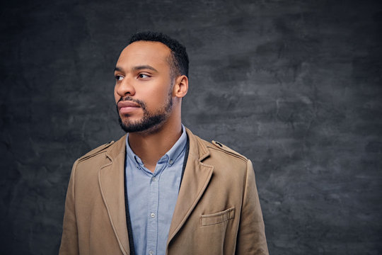 Portrait of casual dressed black American male over grey background.