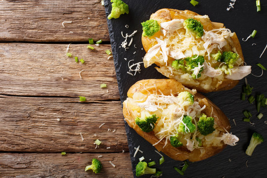 Hearty hot baked potato with broccoli, chicken, onion and cheese close-up. horizontal top view