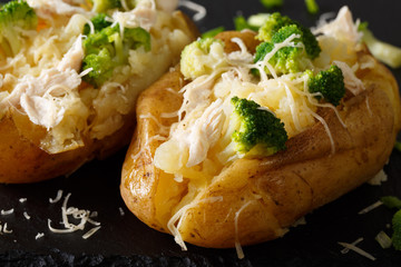 Healthy baked potato with broccoli, chicken, onions and cheese close-up. horizontal