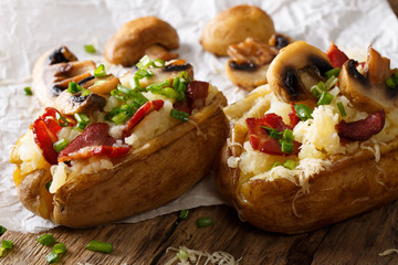 Homemade baked potatoes with bacon, mushrooms, onions and cheese close-up. horizontal