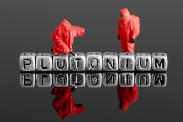 Miniature scale model team in chemical suits with the word plutonium on beads