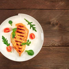 Grilled chicken fillet with cherry tomatoes and salad leaves