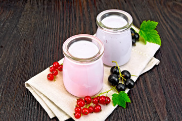 Milk cocktail with red and black currant on dark board