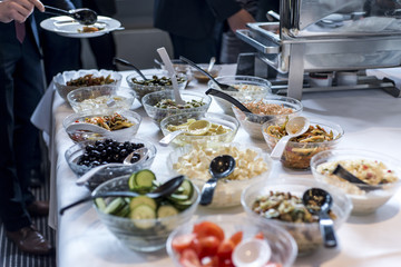 Variety of fresh salads bowls on buffet table business dinner