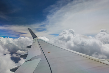 Fototapeta na wymiar Airplane wing on blue sky 
