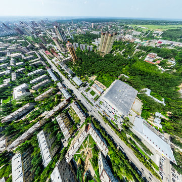 Aerial city view with crossroads and roads, houses, buildings, parks and parking lots, bridges. Helicopter drone shot. Wide Panoramic image.