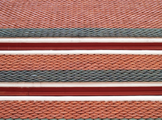repetitive wave striped of colorful roof clay tiles with red wooden eaves