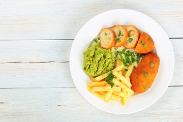 french fries, mashed pea and chicken cutlets