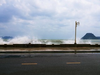 Waves breaking,Big strong wave moved ashore on the road along the sea  Prachuap Bay,Prachuap Khiri Khan,Thailand
