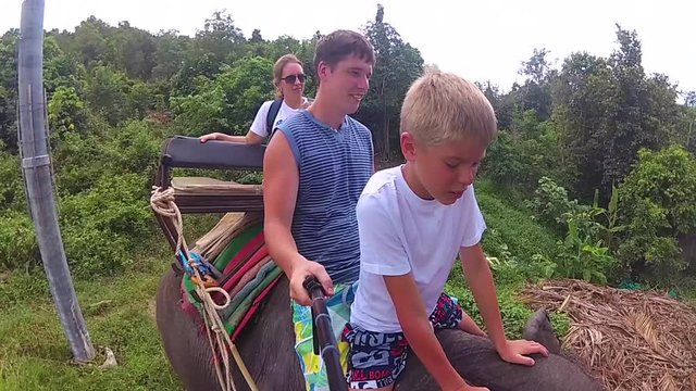 PHANGAN, THAILAND .The family riding on elephants in the tropical forest