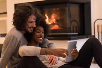 multiethnic couple using tablet computer on the floor