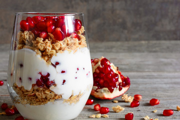 homemade yogurt parfait with granola and pomegranate fruit in a glass