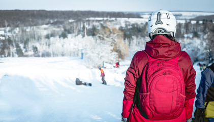 girl in ski suit  on a snowhill view from back